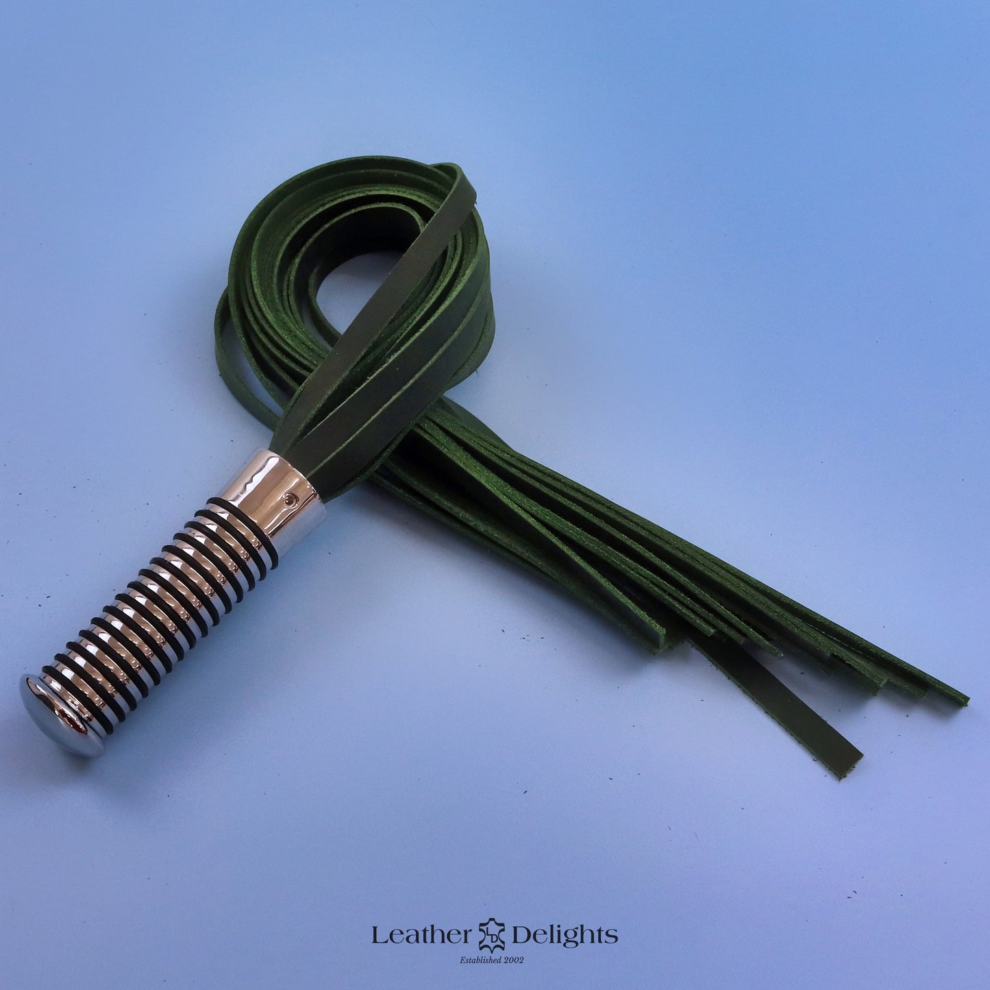 Flogger en cuir vert et noir avec poignée argentée